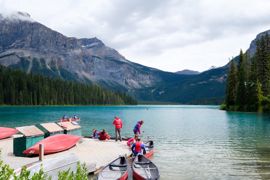 Group enjoying kayaking in a picturesque mountain lake surrounded by lush forests.